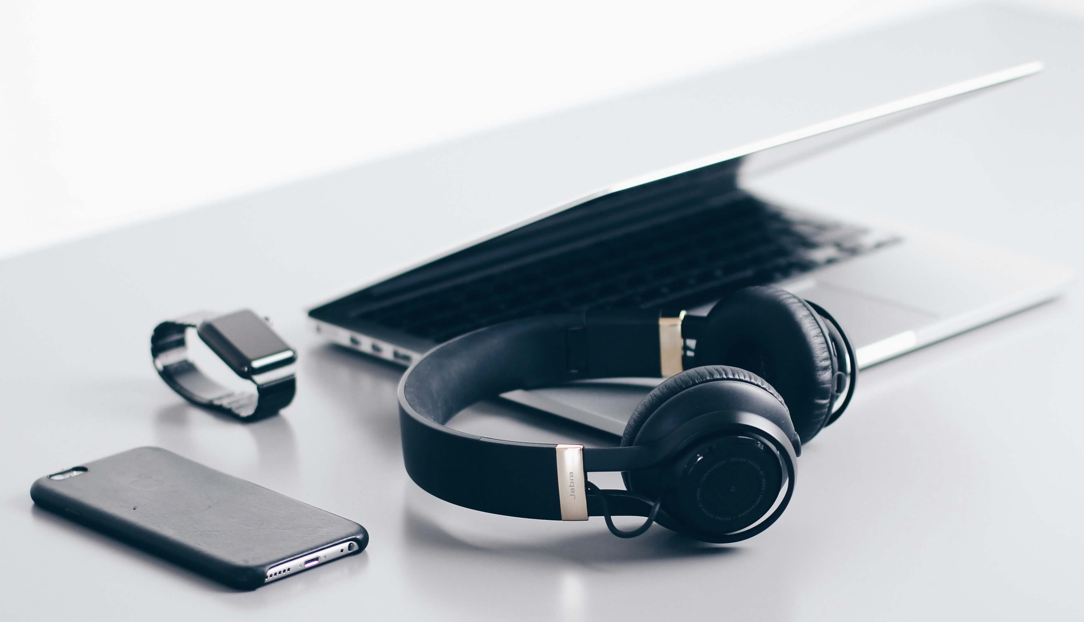 Clean home office desk setup with laptop, keyboard, and productivity accessories
